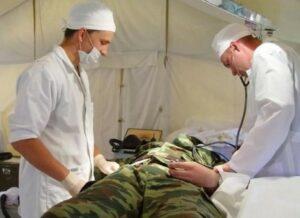 На фото военные врачи принимают раненого солдата в полевом госпитале.